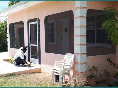 Screen door and window screens being fitted to a home veranda